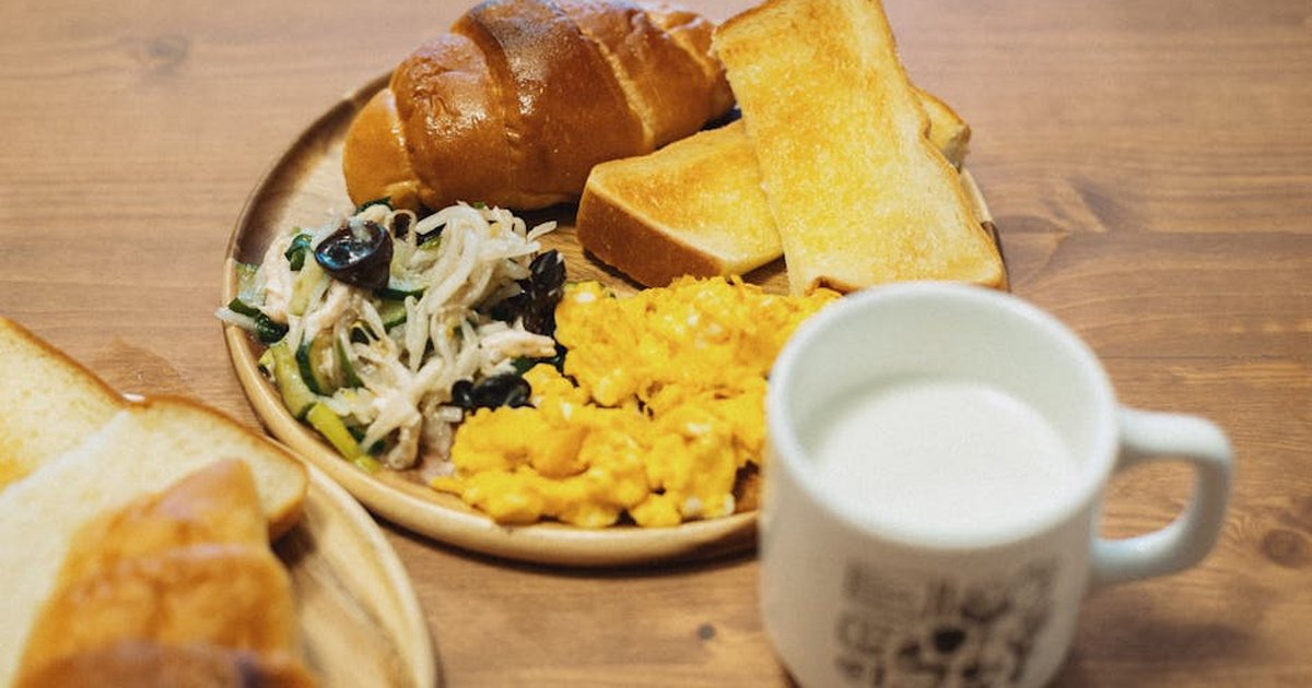 Tasty Japanese breakfast with scrambled eggs, bread, salad, and milk. Captured in Itabashi City, Tokyo.