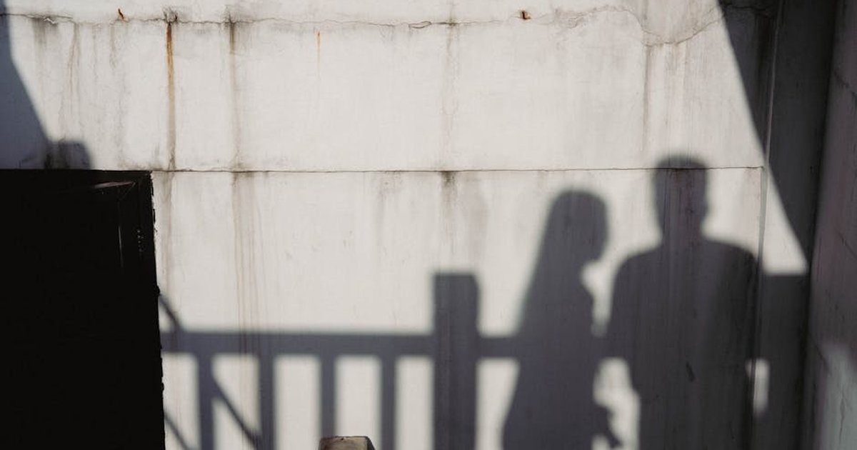 Artistic shadows of a man and woman on a concrete wall, evoking mystery and creativity.