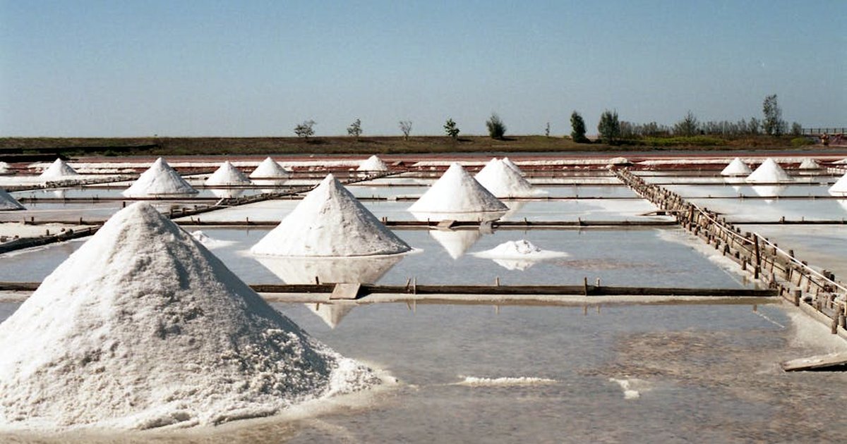 Scenic view of traditional salt fields with salt mounds under a clear sky in Tainan, Taiwan.