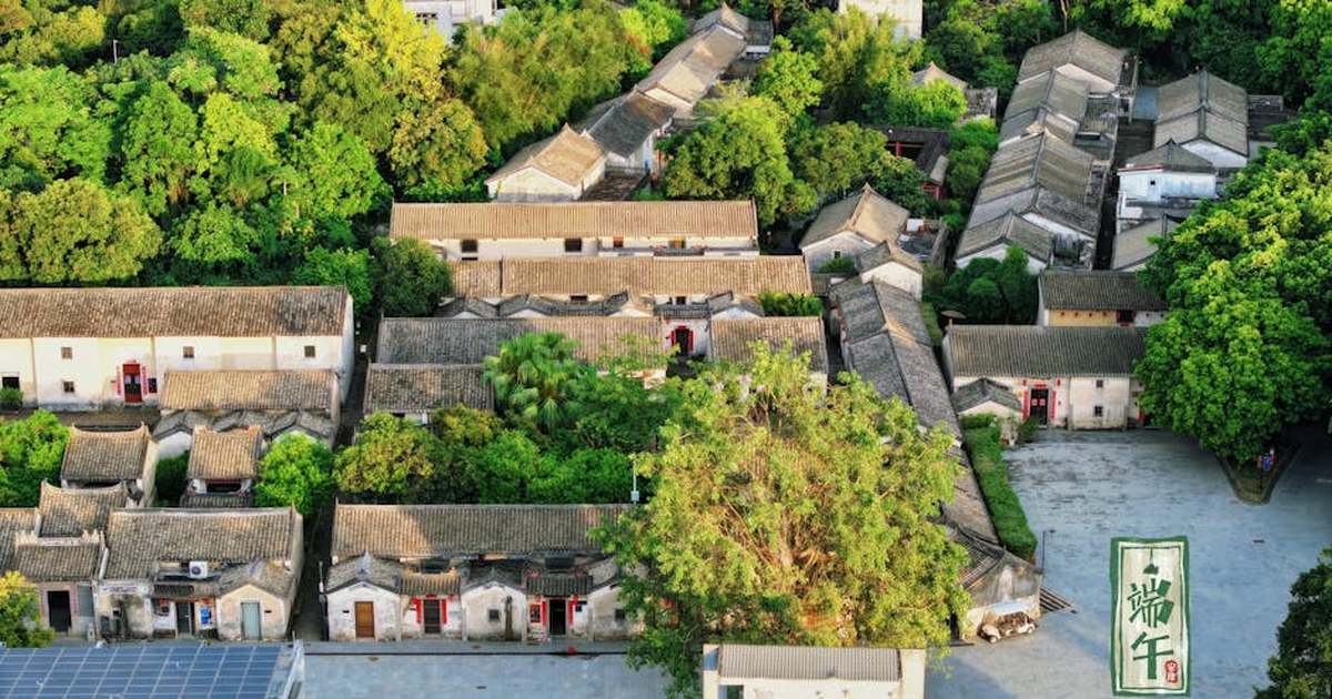 Aerial view of traditional Chinese courtyard houses amid lush greenery in Shenzhen, China.