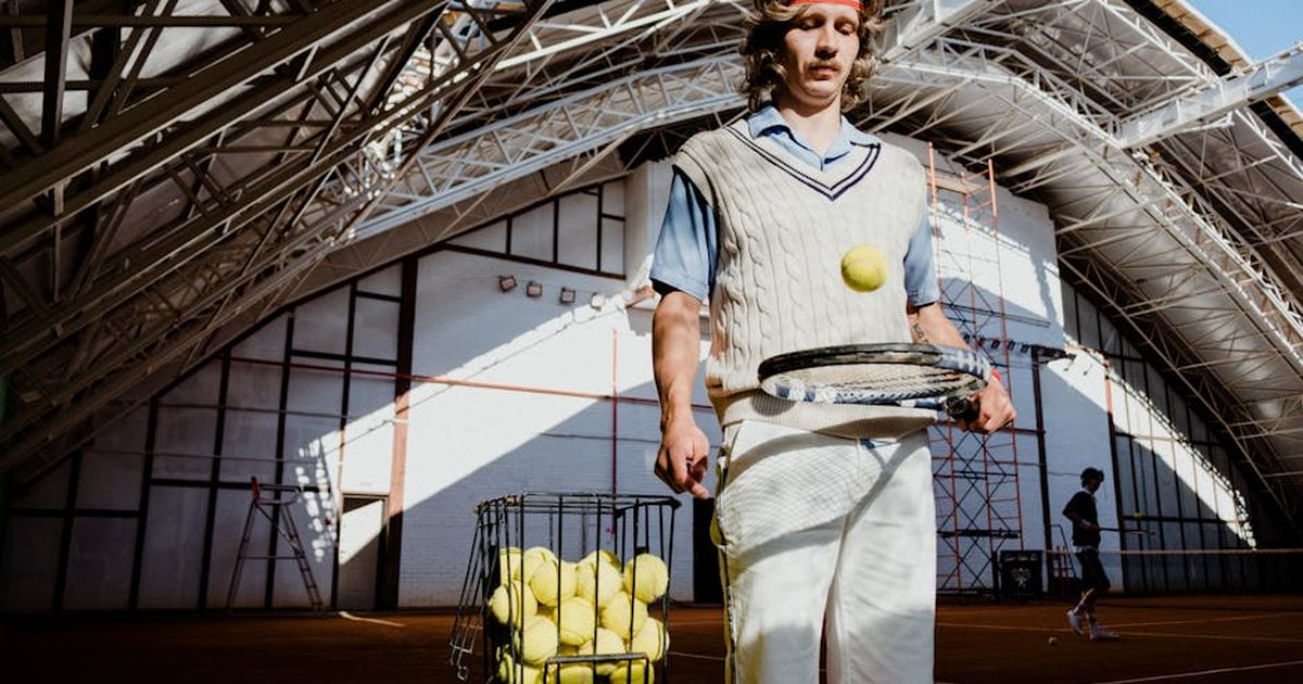 Vintage-inspired image of a tennis player practicing indoors with equipment.