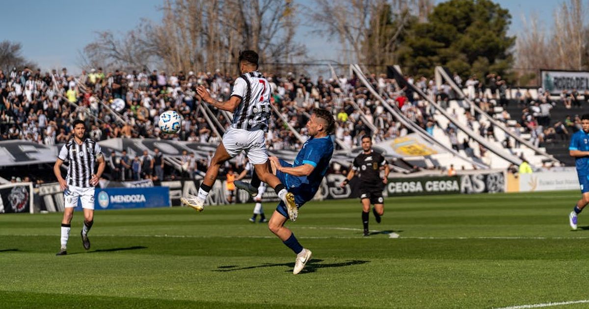 Dynamic scene of players in action during a soccer match at a crowded stadium.