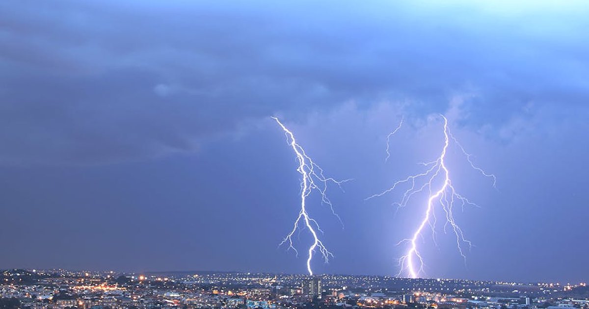 Stunning view of lightning striking over Johannesburg skyline at night, captivating nature's power.