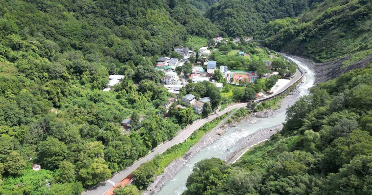 Stunning aerial view of a lush river valley and village in Hsinchu County, Taiwan.