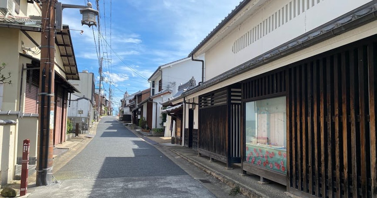 Charming street view in Kyoto with traditional Japanese architecture under a clear blue sky.