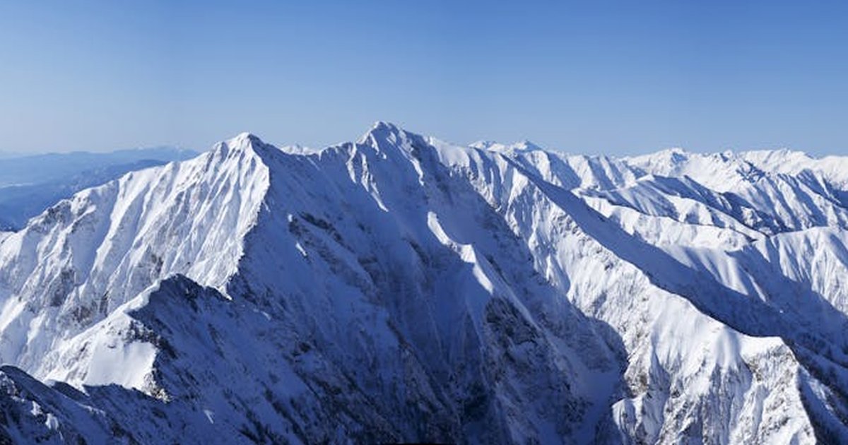 Explore the stunning beauty of snowy mountain peaks under a clear blue sky
