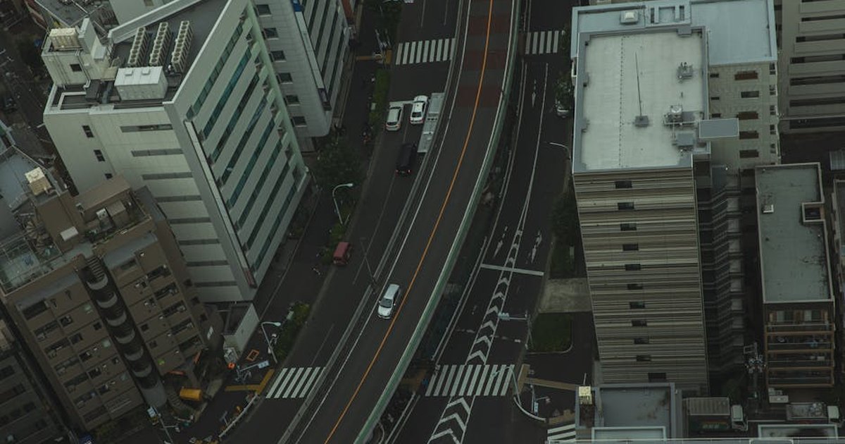 Drone view of residential area in modern city with transport on asphalt roads and multistory houses