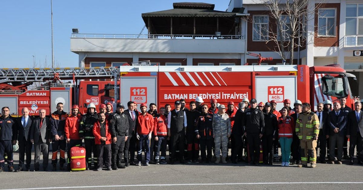 Group of firefighters and officials posing in front of a fire truck in Batman, Türkiye.