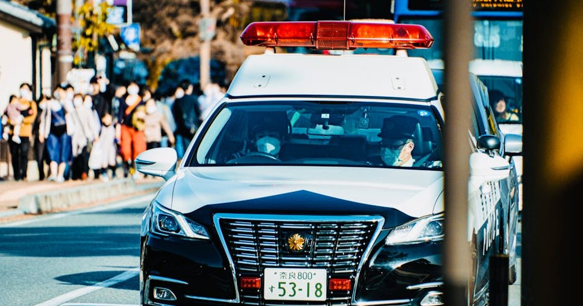 Police car navigating through city traffic, showcasing urban life and community security.