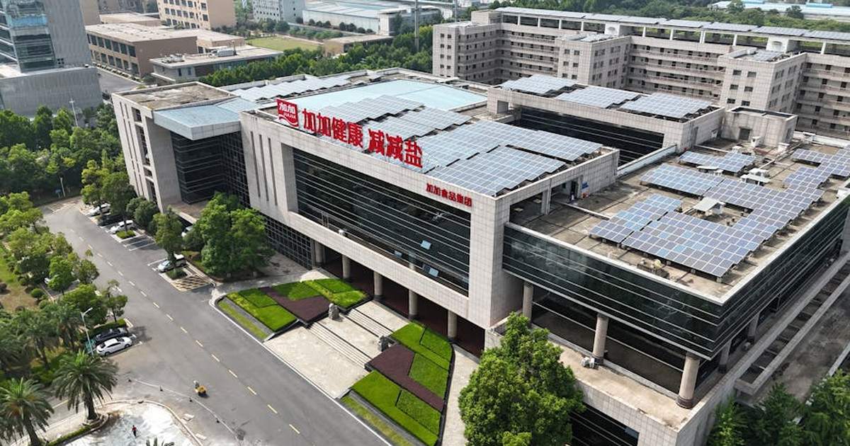 Aerial view of a modern building with solar panels, showcasing sustainable architecture.