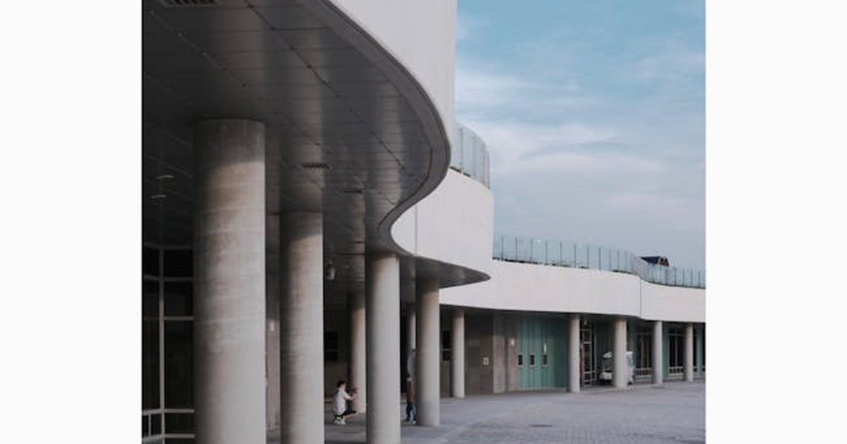Curved concrete building facade and columns under a bright blue sky in Ansan, South Korea.