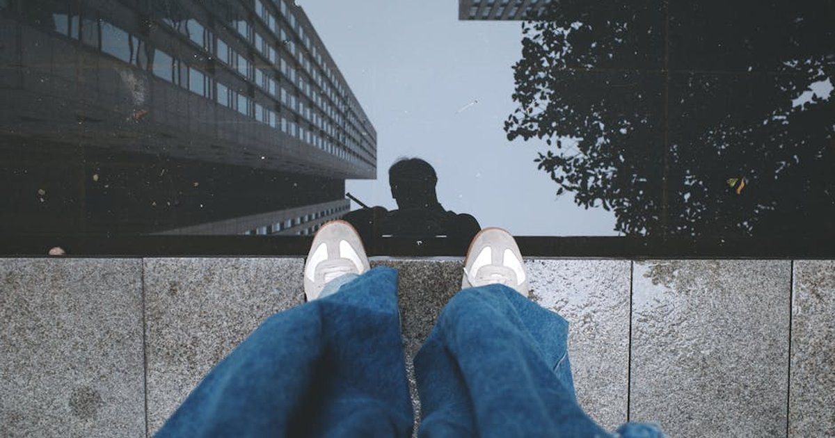 Person reflected in water with buildings, adding an urban touch.