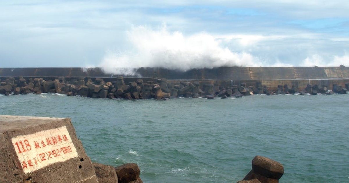 Powerful waves crash against the harbor wall in Wanli District, New Taipei City.