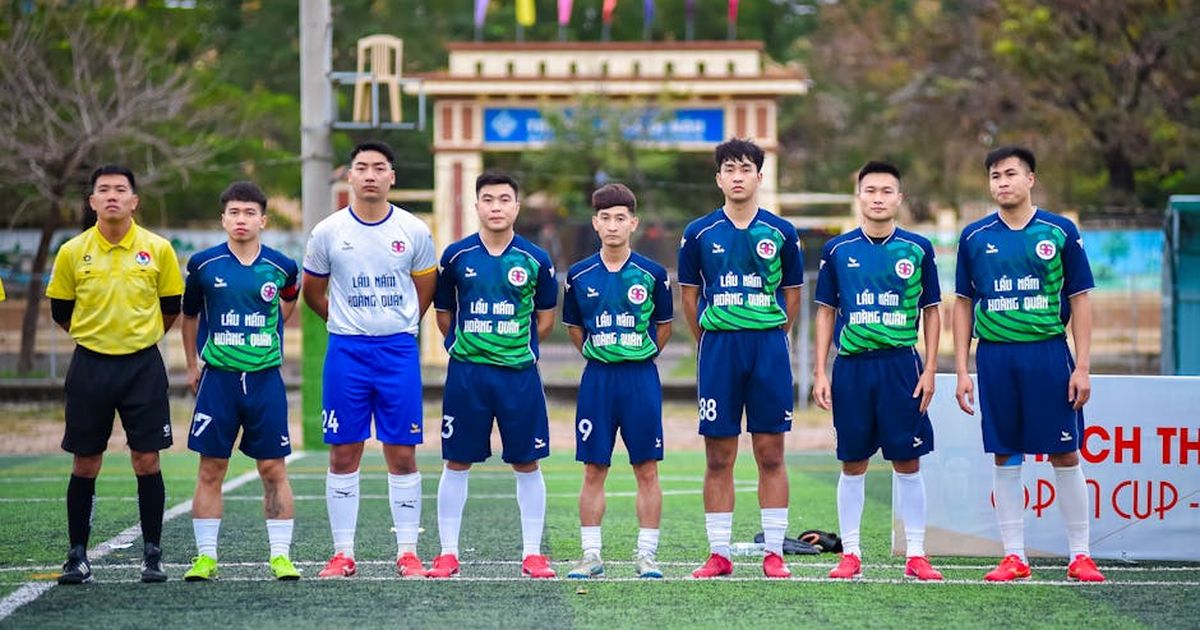 Football team lineup in Hanoi, Vietnam, before a match, showcasing uniforms and team spirit.