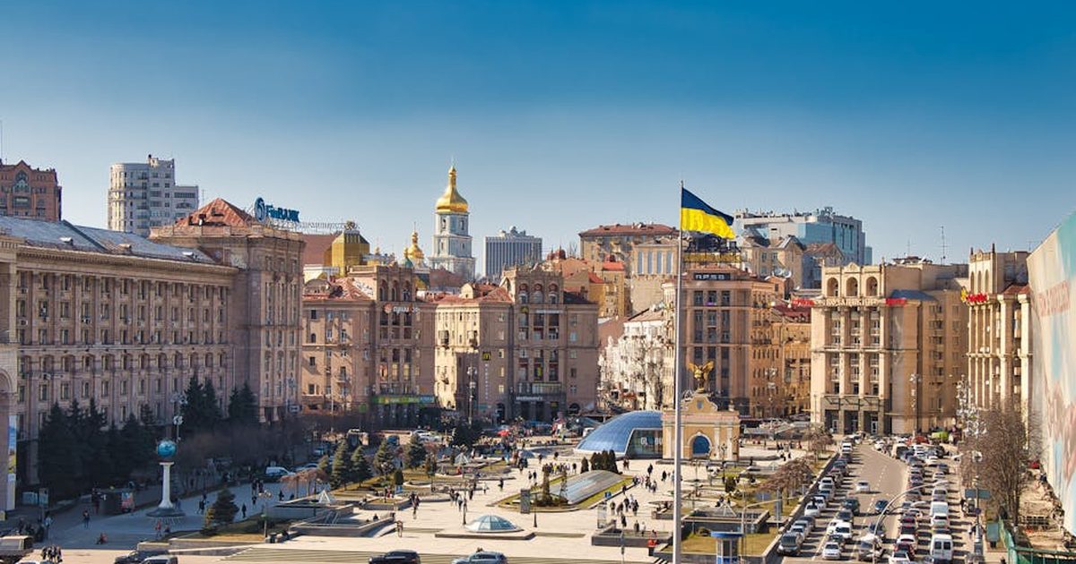 A bustling daytime scene at Independence Square in Kyiv, Ukraine, showcasing historical architecture and city life.