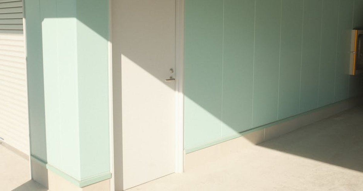 A minimalist indoor scene featuring a door with geometric shadows and pastel walls.