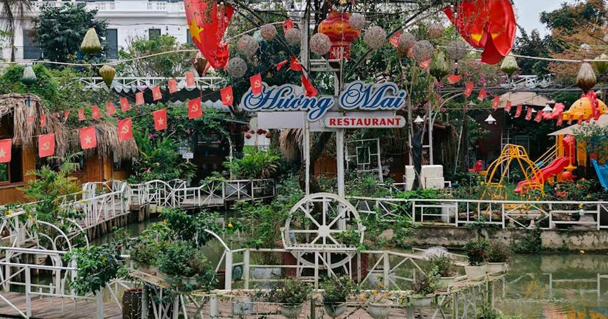 Outdoor view of a Vietnamese restaurant decorated with flags and plants.