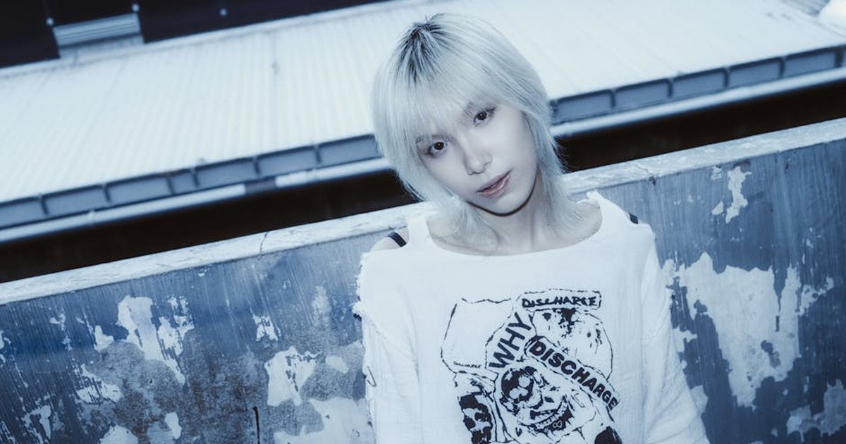 Stylish portrait of a young adult with platinum hair in an urban setting.