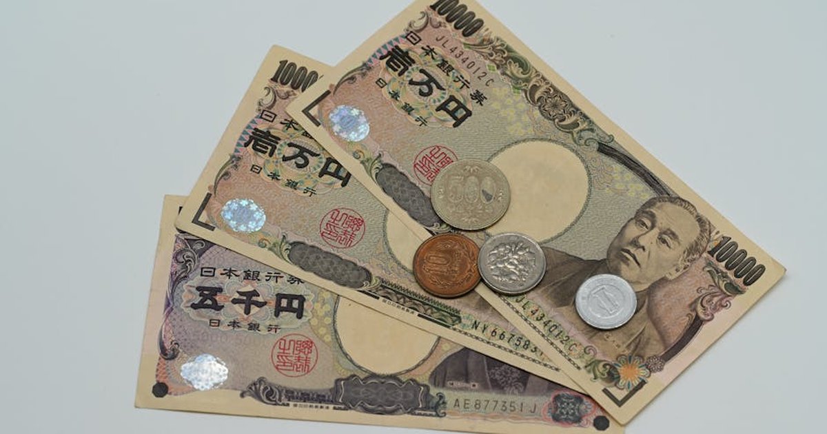 Close-up of Japanese Yen banknotes and coins arranged on a flat surface.
