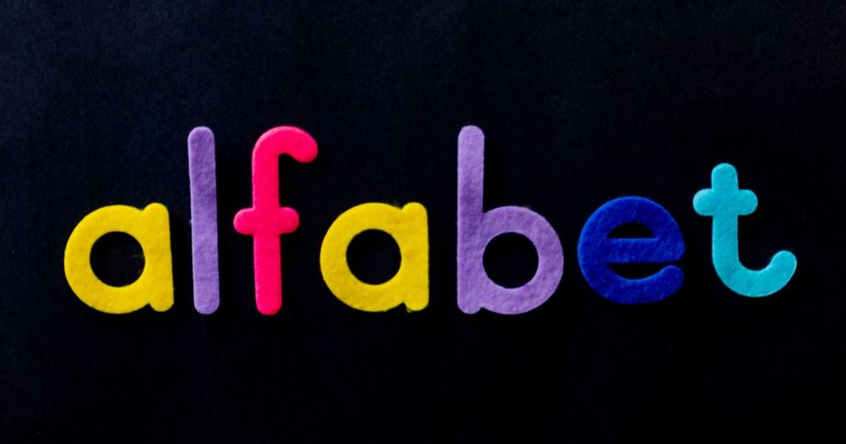 Brightly colored alphabet letters spelling 'alfabet' on a black surface, ideal for educational themes.