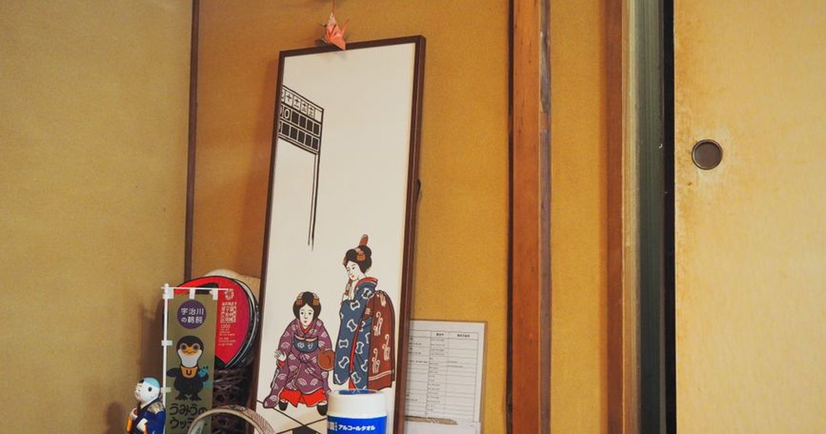Interior detail of vintage styled apartment with authentic painting of Japanese women in national kimonos placed on table near souvenirs