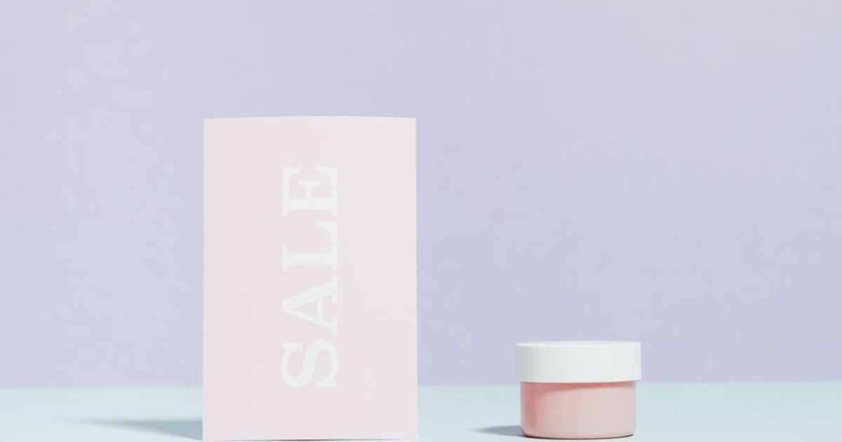 Elegant still life of a sale card and cream jar on pastel background.