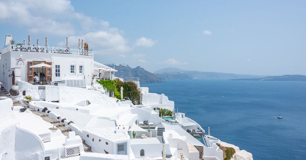 Santorini's iconic white buildings and blue sea create a perfect summer scene ideal for travel enthusiasts.