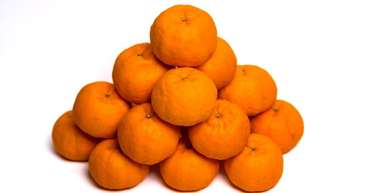 A pyramid of vibrant orange mandarins on a clean white background, showcasing freshness and simplicity.