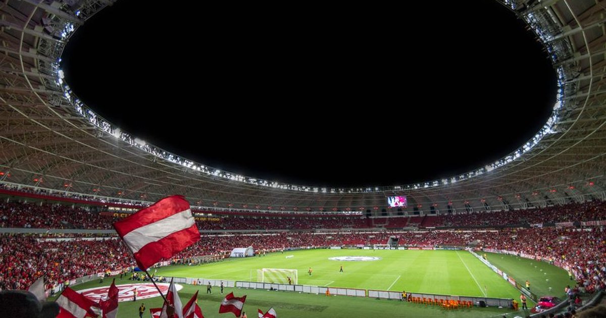 Exciting soccer match with enthusiastic fans in a packed stadium under bright lights.