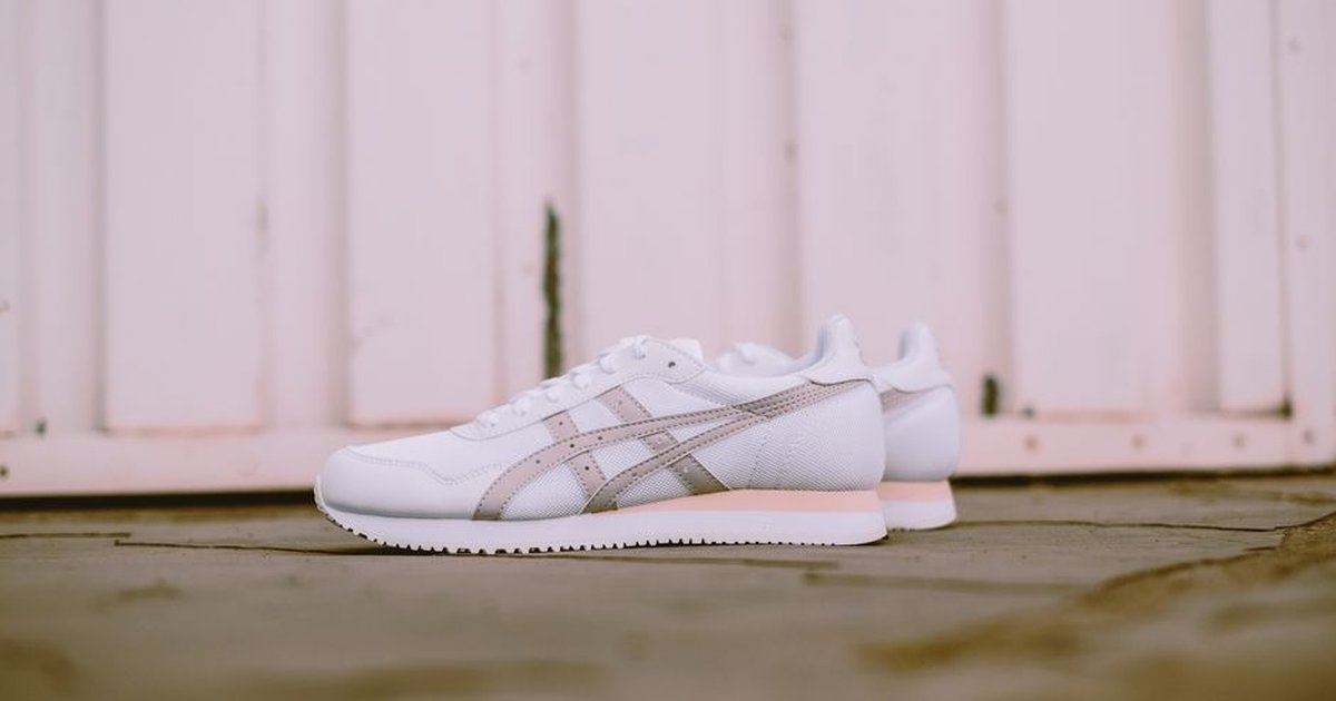 Stylish white sneakers set against a rustic wooden background, perfect for footwear fashion inspiration.