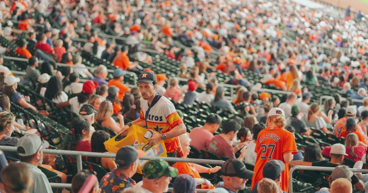 Packed Houston stadium featuring enthusiastic baseball fans during a major league game.