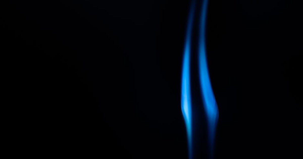 Smooth abstract blue flame against a black background with copy space.