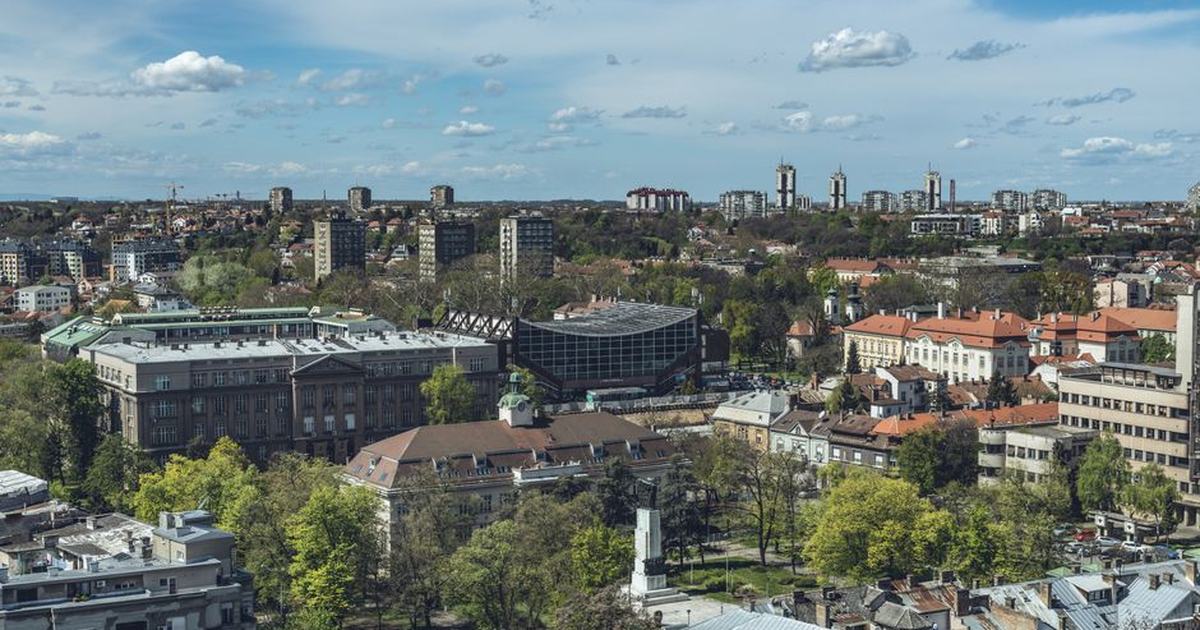 Stunning aerial shot of Belgrade, Serbia showcasing urban buildings and green areas under a clear sky.