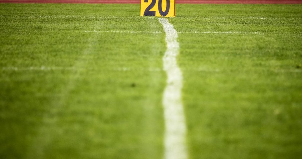 Close-up view of a football field with a 20-yard marker, showcasing vibrant green grass.
