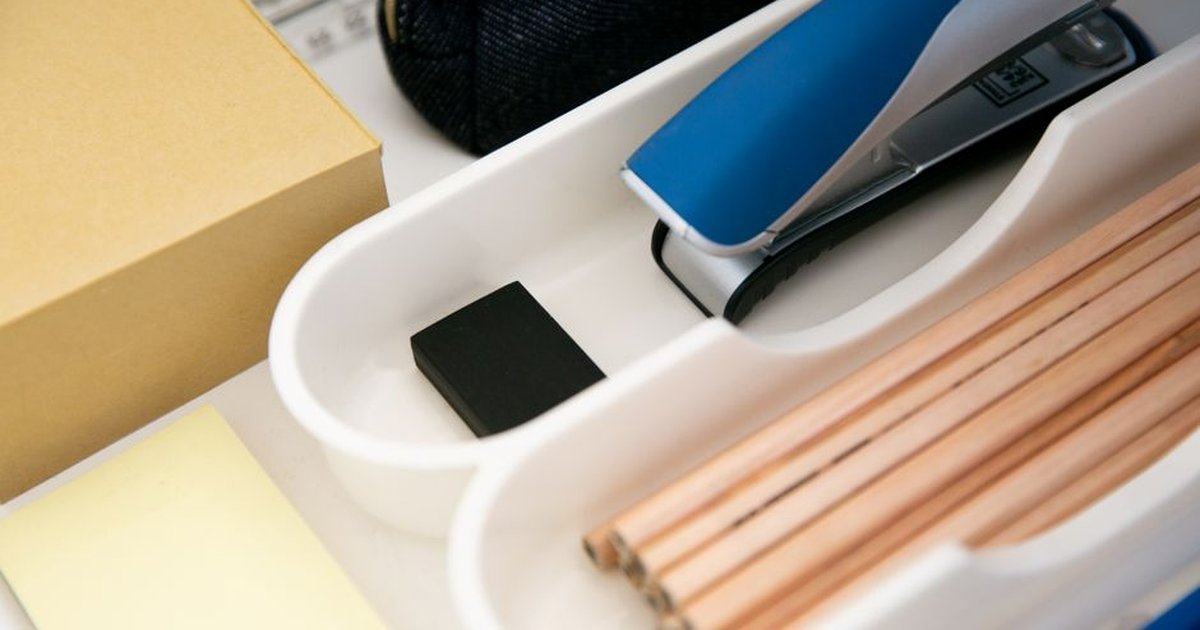 Close-up of an office drawer organized with pencils, stapler, sticky notes and more.