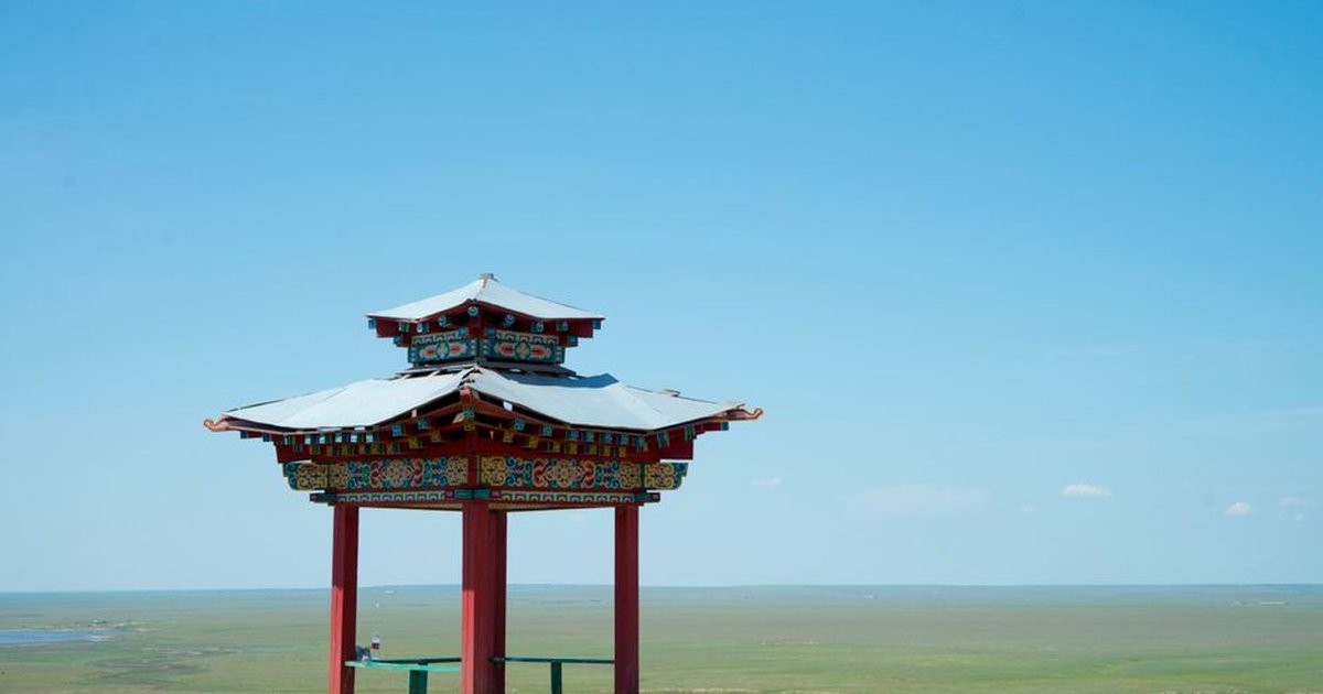 A serene view of a traditional Buddhist pavilion in an open landscape in Kalmykia, Russia.