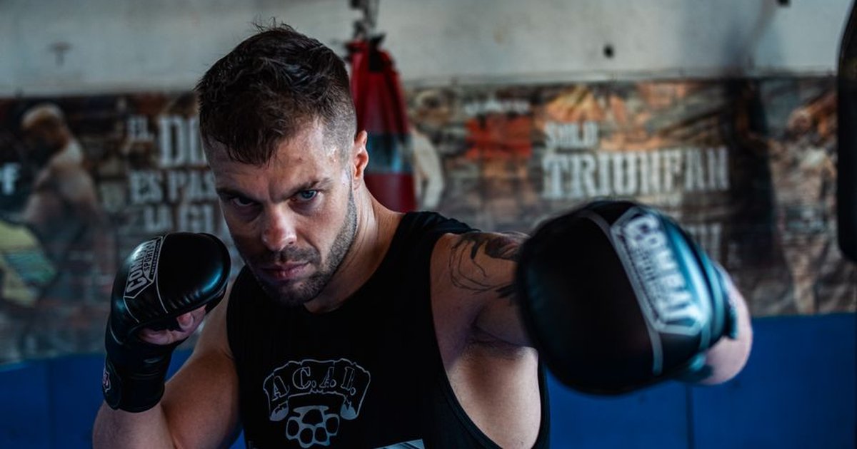 Strong male boxer honing his skills in a gym, showcasing intense focus and athletic agility.