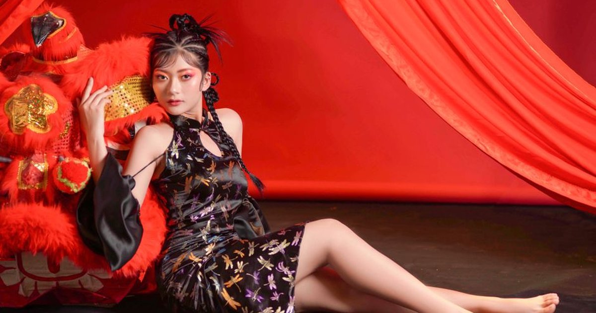 Woman in a floral cheongsam with vibrant red backdrop and decorative elements.