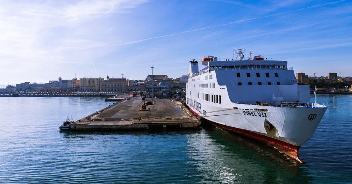 Large white ferry moored in Bari harbor, Apulia, under a clear blue sky.