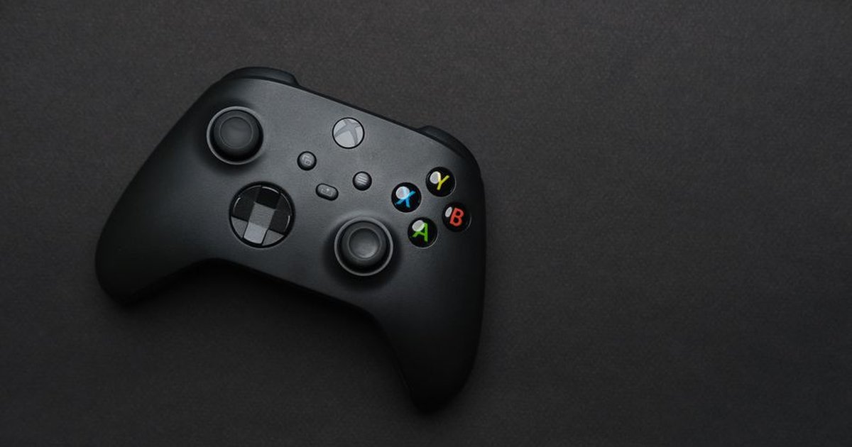 Closeup of a black gaming controller on a dark backdrop, perfect for tech themes.