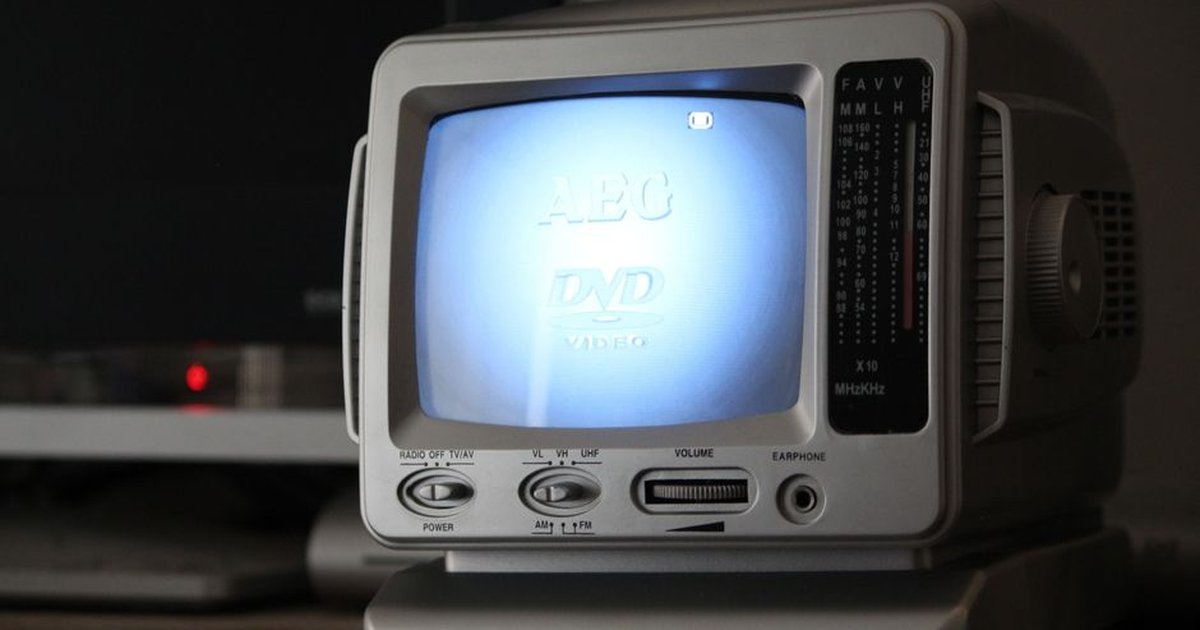 Classic portable CRT television displaying a DVD screen indoors.