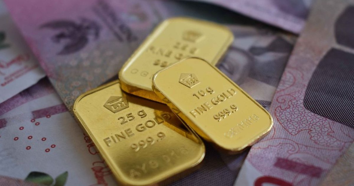 Detailed gold bars layered over Indonesian currency, highlighting wealth and investment.