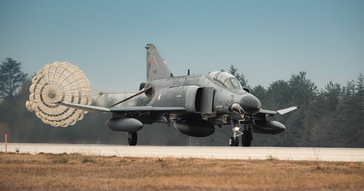 Turkish Air Force jet fighter landing with parachute deployed on runway in Türkiye.