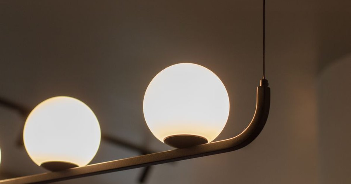 Close-up of contemporary spherical pendant lamp with warm illumination indoors.