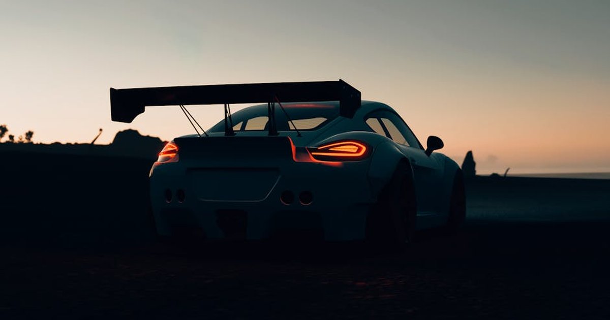 Silhouette of a sleek sports car with a spoiler at dawn, emphasizing speed and adventure.