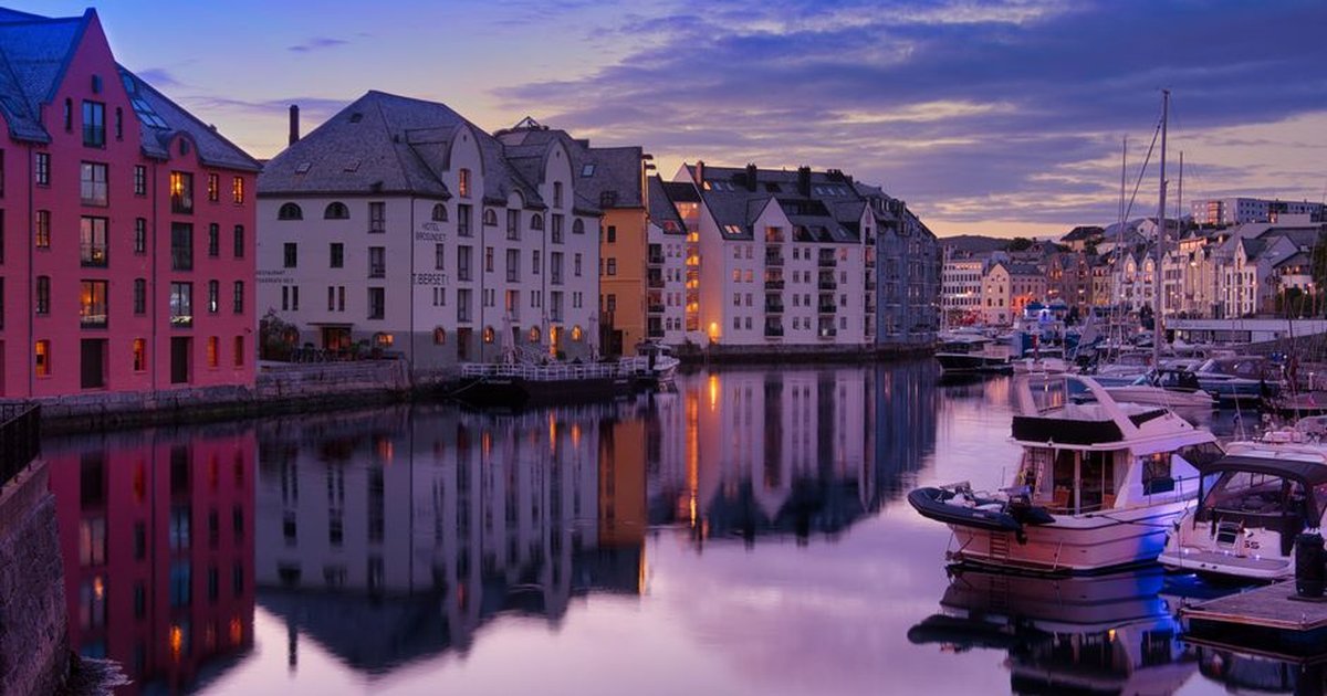 Charming Ålesund waterfront with colorful buildings and boats during dusk. Perfect urban cityscape view.