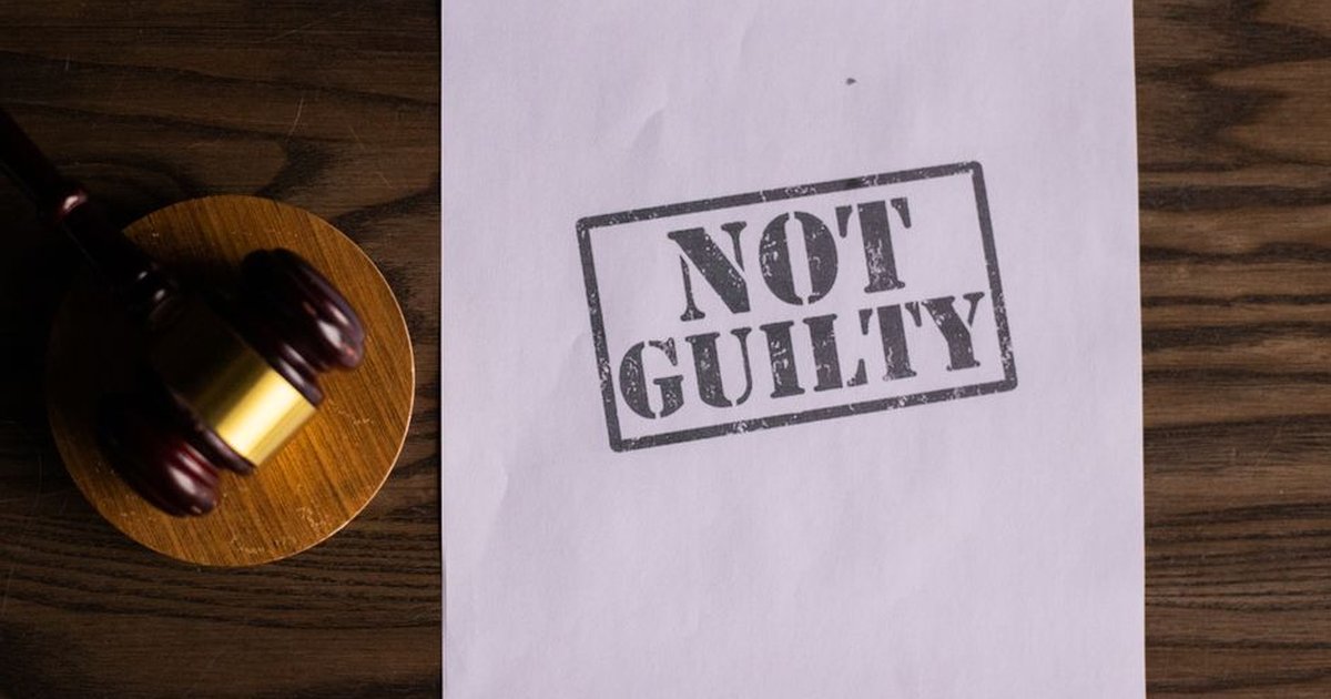 A courtroom document labeled 'Not Guilty' beside a gavel symbolizes justice.