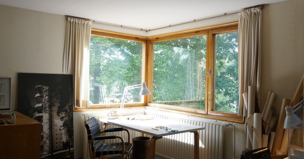 Bright home office with corner windows and minimalist decor, ideal for productivity and inspiration.