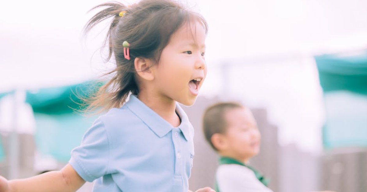 Candid shot of happy children playing outside, showcasing joy and energy.