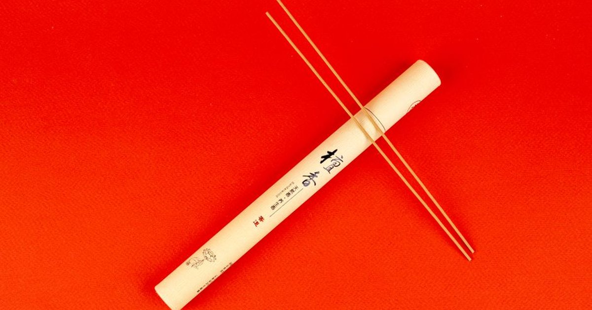Incense sticks and packaging on vibrant red background for aromatherapy and relaxation.